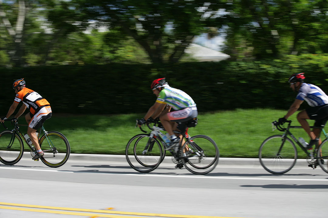 Three cyclists biking in a bike lane in Weston