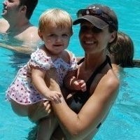 mom holding baby at pool