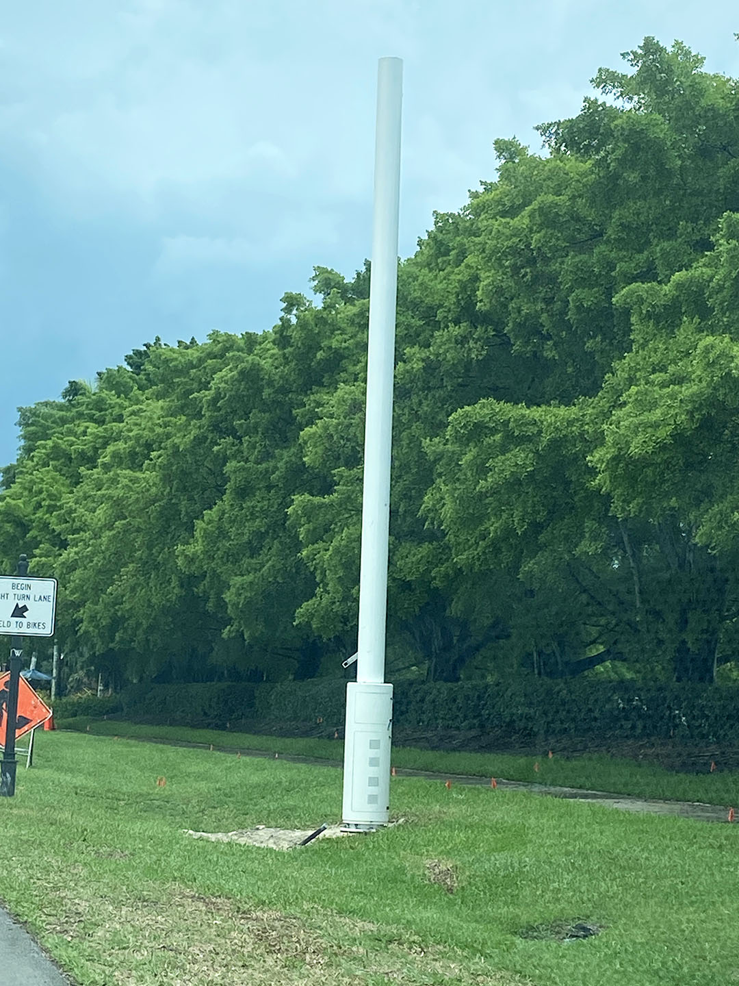 cell antenna in swale area of grass with trees in background