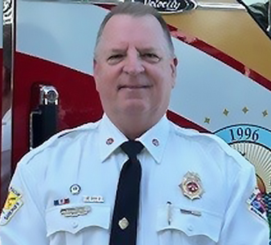 Assistant Fire Chief Gary Harrington in front of fire truck