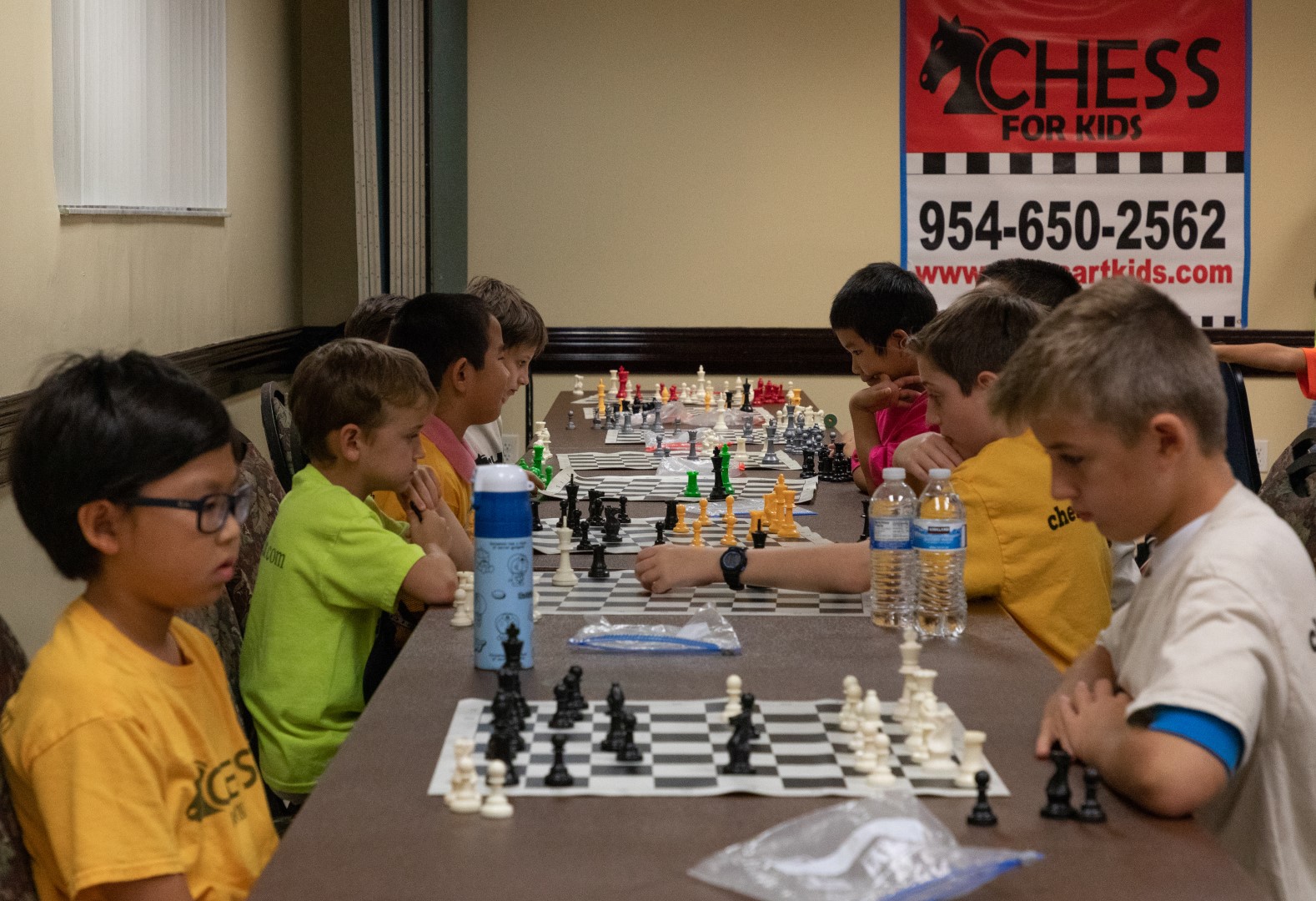 Children play chess as part of the chess club at the Weston Community Center